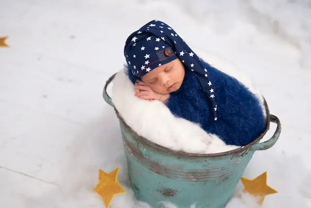 Tiny Baby Asleep on a Bed of Cotton in Bucket